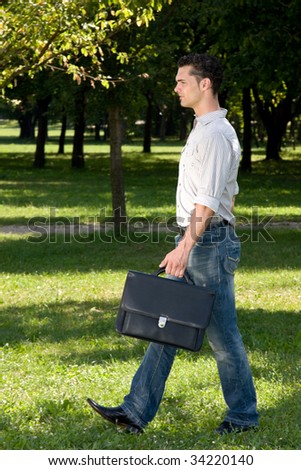 businessman walking on his own way in a park