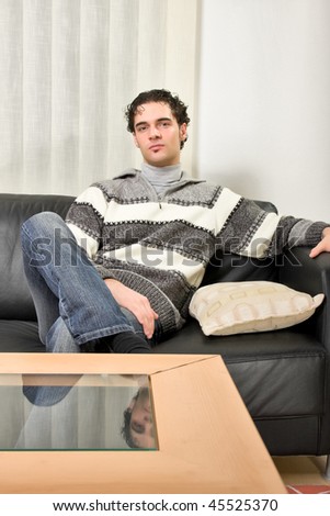 young handsome guy sitting on a sofa at home