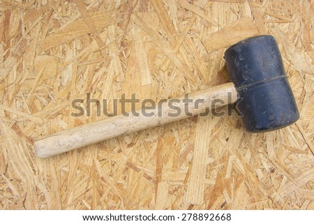 A mallet with wooden handle on a wooden background