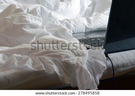 computer on white blanket, white interior, white sheet,bedroom