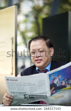 Asian businessman reading newspaper