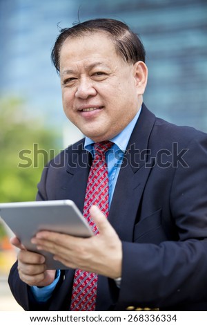 Asian business man in suit using tablet