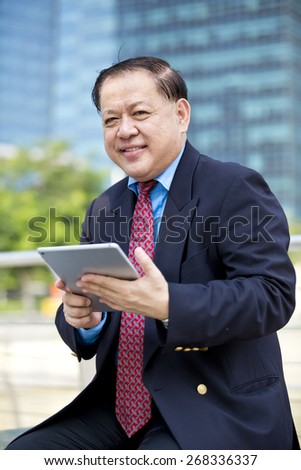 Asian business man in suit using tablet