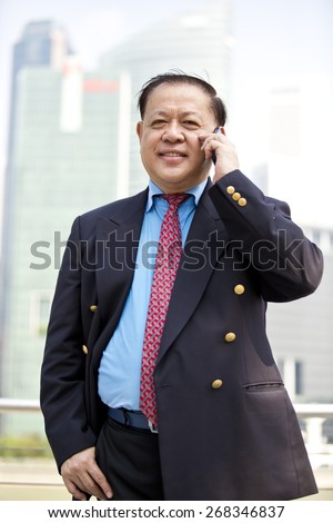 Asian businessman in suit talking on smart phone