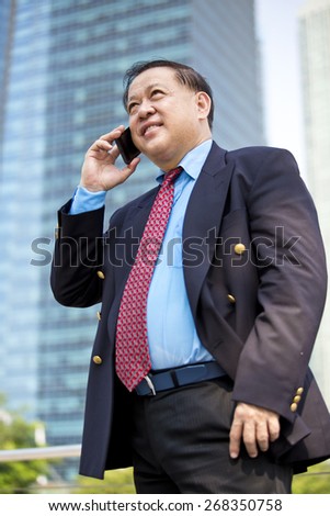 Asian businessman in suit talking on smart phone
