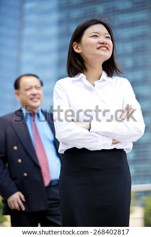 Asian senior businessman & young female executive portrait