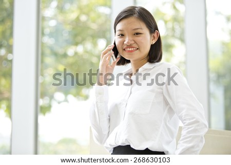 Asian young female executive talking on phone