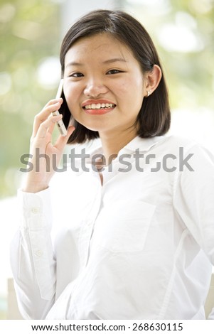 Asian young female executive talking on phone