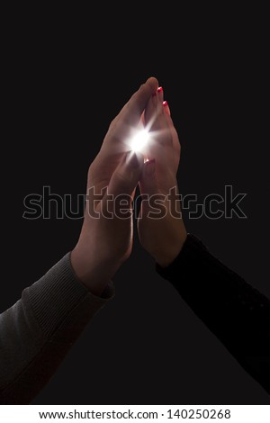 Touching. Silhouette of male and female hands touching each other with light ray in between