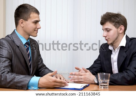 Business negotiations. Buyer thinks about the offer made by salesman sitting in front of him.