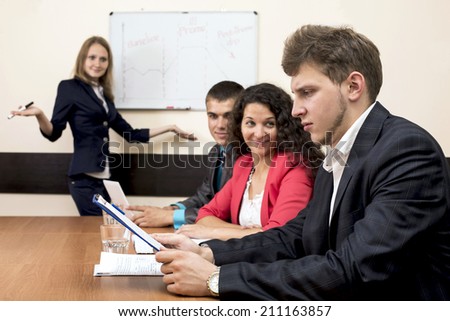 Corporate training. The participant does not agree with the concept delivered by instructor and critically looks at the workbook.