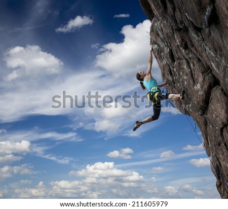 Female rock climber hanging over the abyss