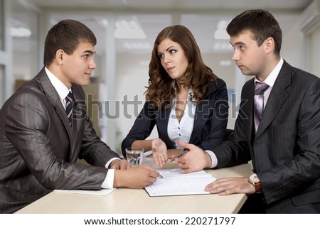 Negotiating the deal. Three business people discuss the deal. One female, two male, business dress code,