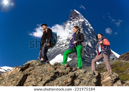 Family of climbers. Farther and daughters walk on the mountain ridge. High alpine landscape on the background