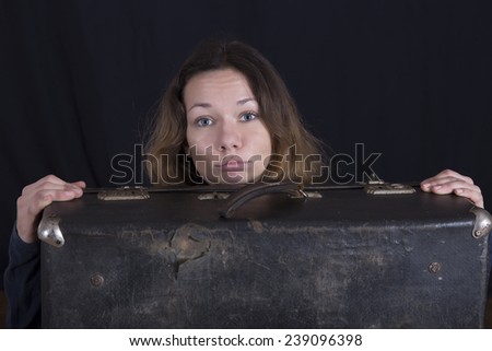Young lady with stylish vintage suitcase Face of female behind the surface of stylish old fashioned broken suitcase