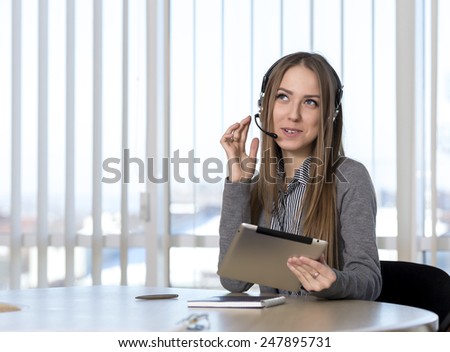 Dreaming female customer support officer. Portrait of smiling cheerful customer support phone operator in headset talking to customer.