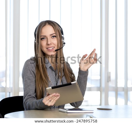 Female customer support officer looking to the camera. Portrait of smiling cheerful customer support phone operator in headset talking to customer