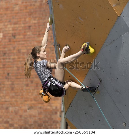 Female climber hangs on her arm and heel on the track of lead climbing competitions. National Climbing Championship, Dnepropetrovsk, Ukraine, May 23, 2014, Female Semifinal, Lead climbing