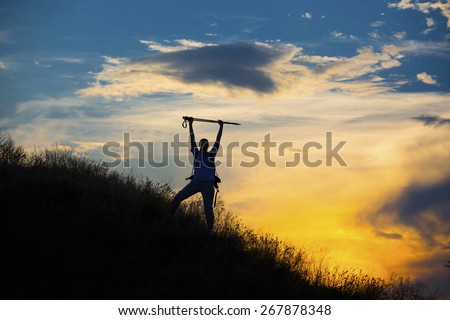 Silhouette of female with raised hands. Colorful sunset and body of human with triumphantly raised hands