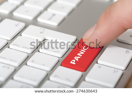 Click panic button. Male finger clicking on red panic button on white grey keyboard