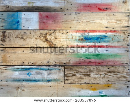 Wood wall warm brown texture background with flags. Image of wooden plank wall with iron nails and scratches flags of different countries painted on it