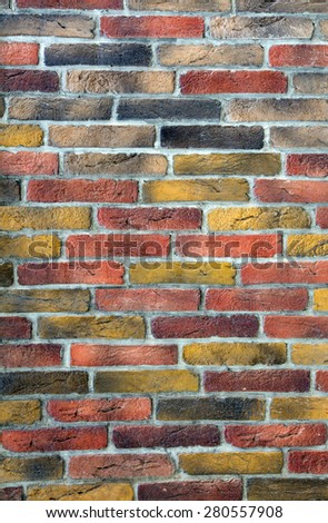 Brick wall background. Image of brick wall made of many different colors individual bricks yellow red grey
