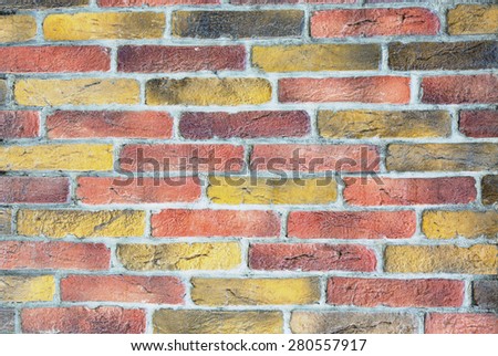 Brick wall background. Image of brick wall made of many different colors individual bricks yellow red grey