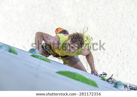 Male athlete makes hard move on climbing wall. National Climbing Championship, Lead climbing qualification round. Dnepropetrovsk, Ukraine, May 22, 2015