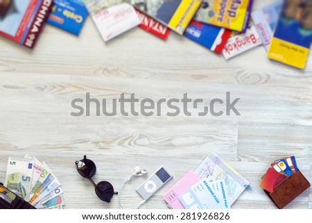 Travel destinations. Conceptual background for travel topic. Rough wooden desk from above passport, foreign cash notes, cards and maps
