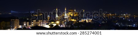 Wide angle panorama of Istanbul old city district at nightlight illumination\
Including most famous attractions Sophia and Blue Mosque with water of Bosporus and Asian side of town on background