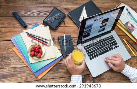 Digesting the news concept. Countryside working room vintage wooden desk laptop digital news internet page opened on screen man top view working keyboard drinking juice business items creative mess
