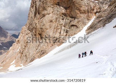 Trekking in Himalaya Hikers Walking Up on Glacier in Nepal India Himalaya Way up to high altitude famous attraction with Snow Climbing and trekking gear mountain sunny day Rock Moraine on background