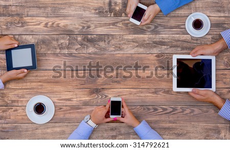 High-Tech Human Generation Lifestyle\
Hands of Group Young People Sitting At Natural Vintage Looking Wood Desk Using Variety Electronic Gadgets