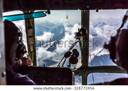 View throw Helicopter Cockpit Flying at High Altitude Mountain Pass in Remote Area of Asia