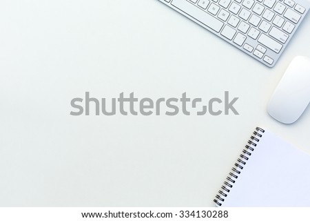 Image of White Office Table with Computer Keyboard Mouse and Paper Notepad Top View