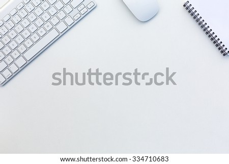 Image of White Office Desk with Computer Keyboard Mouse and Notepad from above