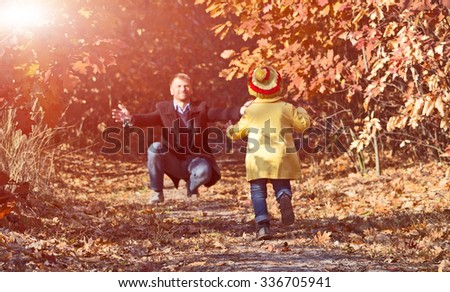 Funny Baby Girl Running towards Open Arms of Her Father along Alley in Autumnal Forest with Shine Shining Throw Golden Leaves