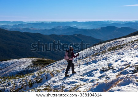 Female Athlete Sport Clothing carrying Backpack Walking Up Mountain Peaks Sunlight Sky Majestic Summits Background