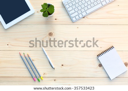 Working Place of Hipster on light Wooden Desk with Stationery Electronics and green Plant