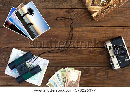 Travel Memories Vintage Composition with old Camera exotic Countries Currency Notes handmade Travel Book Binoculars and opened Passport with many visas entry stamps Color Photos on Hardwood Background