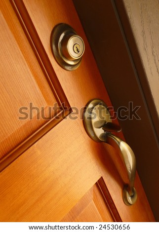 Brass door handle and deadbolt on wooden door