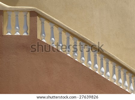 Warm colors on a stucco building with white balustrade staircase railing