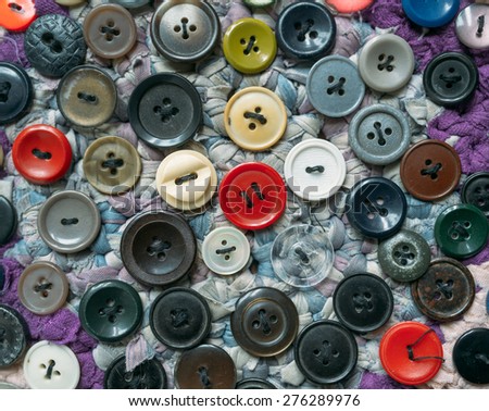 old , colorful and different shapes buttons, sewn to the seat cushion.