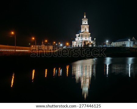 Beautiful Russian Christian church on the banks of the river at night in windy weather .