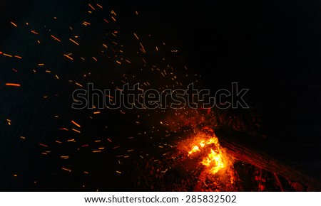 Magic fire on the river bank . Sparks, flames and other wonderful backgrounds for your text.