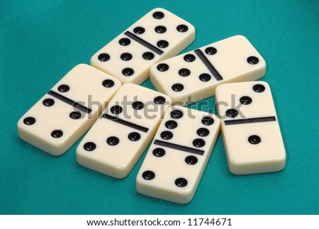 Dominoes game on green fabric background