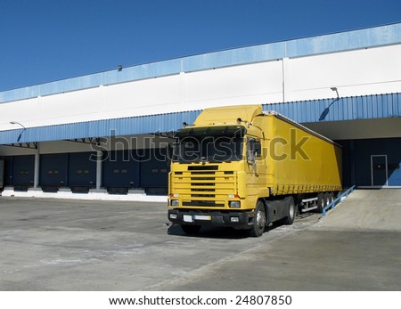 Yellow semi truck sitting at a loading dock