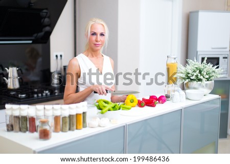 Happy woman cooks in the kitchen