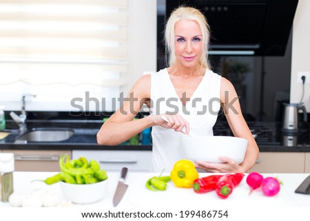 Happy woman cooks in the kitchen