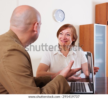 Elderly woman questioning young man about letters from bank